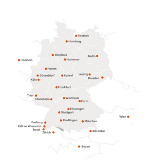 Die Karte zeigt die Standorte der SRH Fernhochschule in Mitteleuropa. Deutschland ist zentriert dargestellt, angrenzende Länder wie die Schweiz, Österreich, Italien (Südtirol) und die Niederlande sind ebenfalls sichtbar. Orange Punkte markieren die Studienzentren. In Deutschland sind folgende Städte gekennzeichnet: Berlin, Hamburg, Hannover, Leipzig, Dresden, Düsseldorf, Köln, Hamm, Trier, Mannheim, Frankfurt, Stuttgart, Freiburg, München, Riedlingen, Wertheim, Ellwangen, Fürth, Diepholz und Zell im Wiesental. In der Schweiz ist Zürich markiert, in Österreich Wien und Kitzbühel, in Italien Bozen sowie in den Niederlanden Haarlem.