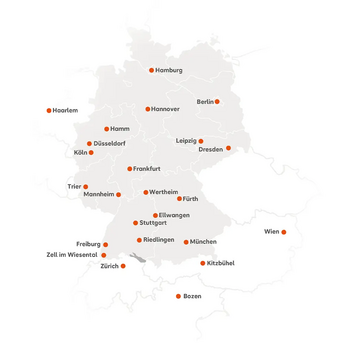 Die Karte zeigt die Standorte der SRH Fernhochschule in Mitteleuropa. Deutschland ist zentriert dargestellt, angrenzende Länder wie die Schweiz, Österreich, Italien (Südtirol) und die Niederlande sind ebenfalls sichtbar. Orange Punkte markieren die Studienzentren. In Deutschland sind folgende Städte gekennzeichnet: Berlin, Hamburg, Hannover, Leipzig, Dresden, Düsseldorf, Köln, Hamm, Trier, Mannheim, Frankfurt, Stuttgart, Freiburg, München, Riedlingen, Wertheim, Ellwangen, Fürth und Zell im Wiesental. In der Schweiz ist Zürich markiert, in Österreich Wien und Kitzbühel, in Italien Bozen sowie in den Niederlanden Haarlem.