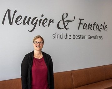 Frau stehen vor Wand mit Aufschrift 