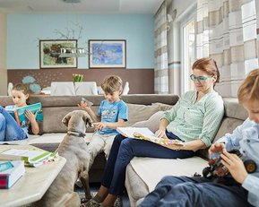 Stipendium für erfolgreiche Familienmanager | Pressemitteilung SRH Fernhochschule Frau mit Kinder auf dem Sofa