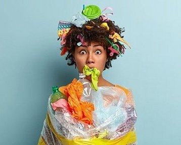 Frau in Plastikmüll bekleidet