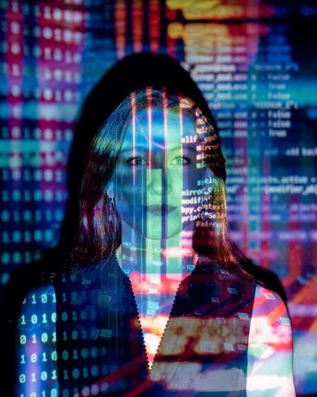 Eine Person steht vor einem Hintergrund aus bunten digitalen Codes und Datenströmen, die über ihr Gesicht projiziert werden. Die Darstellung vermittelt ein Gefühl von Technologie und Datenanalyse.