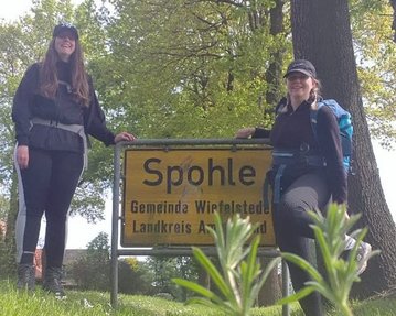 Ann-Kathrin Kunzmann zusammen mit einer Begleiterin vor einem Ortschild mit der Aufschrift "Spohle" stehend