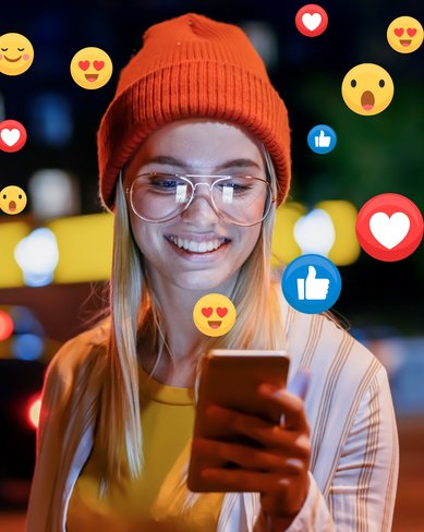 Eine lächelnde Frau mit Brille und rotem Hut schaut auf ihr Smartphone, umgeben von Symbolen für Likes und Emojis, während sie in einer städtischen Umgebung steht.