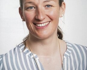srh-fernhochschule-studierende-lerntherapie-wulff Eine lächelnde Frau mit blonden Haaren trägt ein gestreiftes Hemd. Sie hat Ohrringe und schaut direkt in die Kamera.