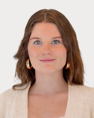 Junge Frau mit langen, braunen Haaren und großen Ohrringen, trägt einen hellen Pullover und schaut direkt in die Kamera.